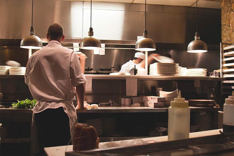 Chefs using stainless steel work tables